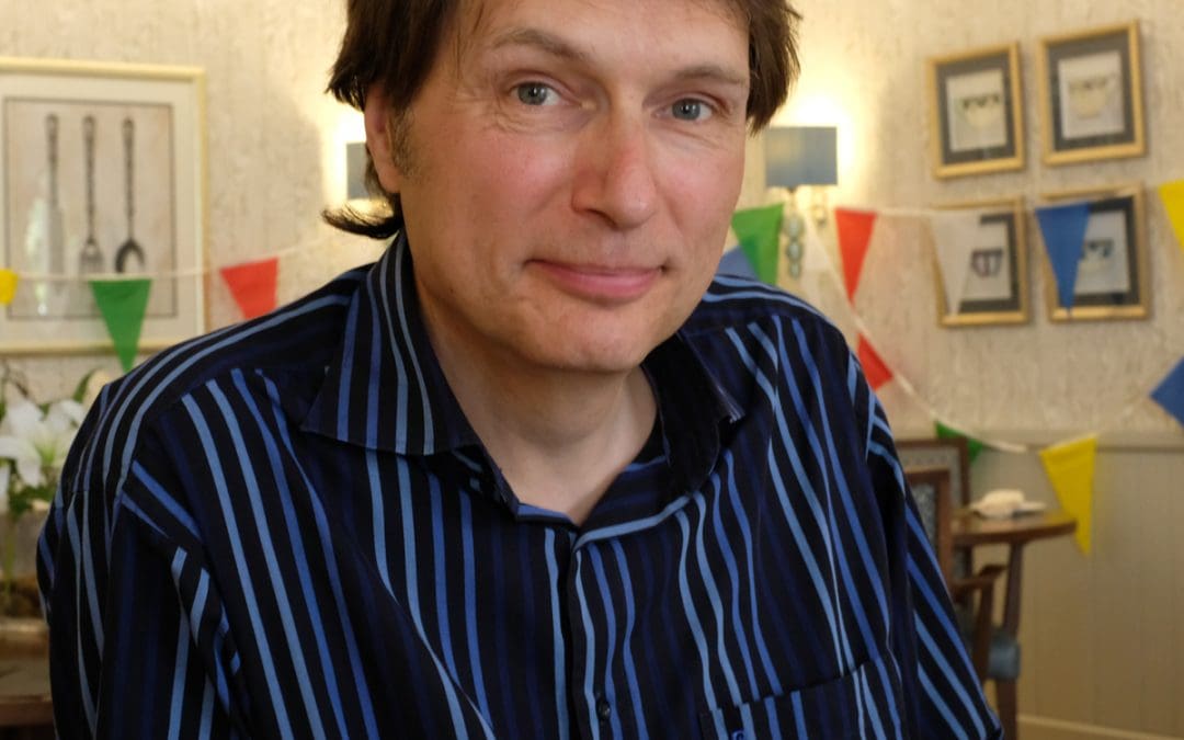 A man with short dark hair wearing a blue striped shirt