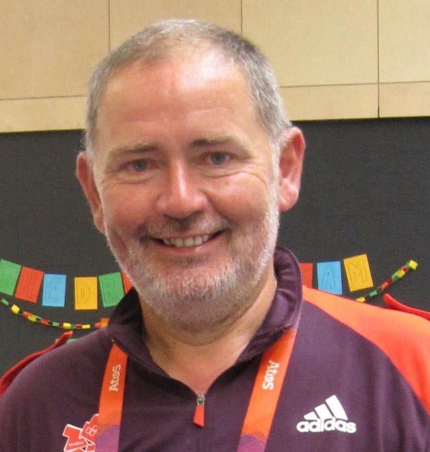 a white man with short hair and beard wearing a sports t shirt