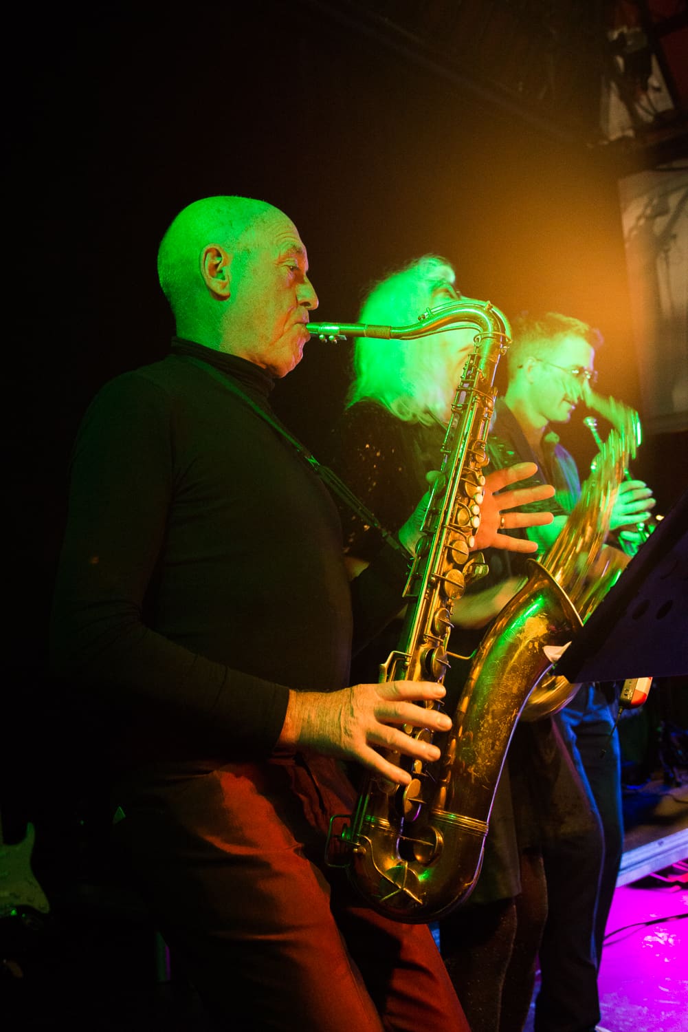 A groups of musicians with saxophones perform on stage